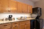The kitchen area boasts of ample solid surface counter space with undermount lighting